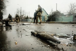 Żołnierze ukraińscy sprawdzają wrak zniszczonej rosyjskiej kolumny pancernej na drodze w Buczy, na przedmieściach na północ od stolicy Kijowa.