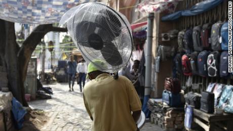 Mężczyzna trzyma wentylator podczas fali upałów w Kalkucie w Indiach.