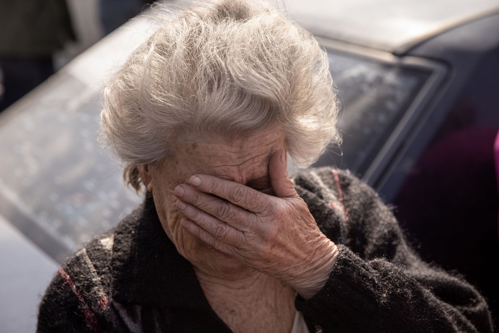 81-letnia Dina z Mariupola reaguje po przybyciu samochodem do punktu ewakuacji osób uciekających z Mariupola, Melitopola i okolicznych miast kontrolowanych przez Rosję 2 maja 2022 r. w Zaporożu na Ukrainie. 