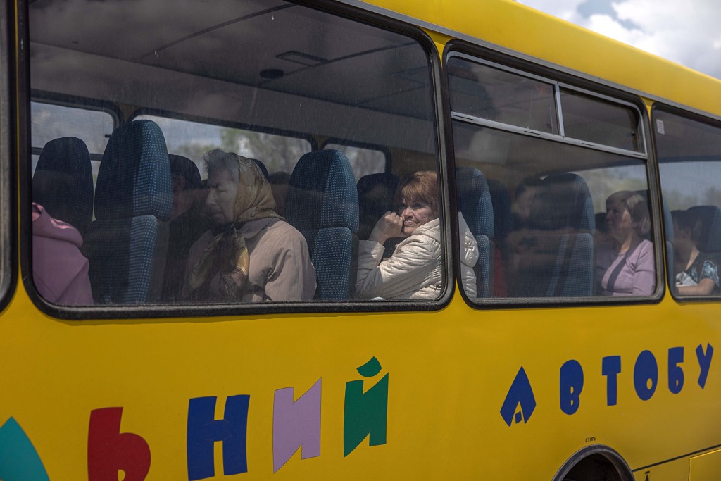 Osoby wewnętrznie przesiedlone siedzą w autobusie po przybyciu z frontowego miasta Urekiew, w punkcie ewakuacyjnym w Zaporożu na Ukrainie, 2 maja 2022 r.