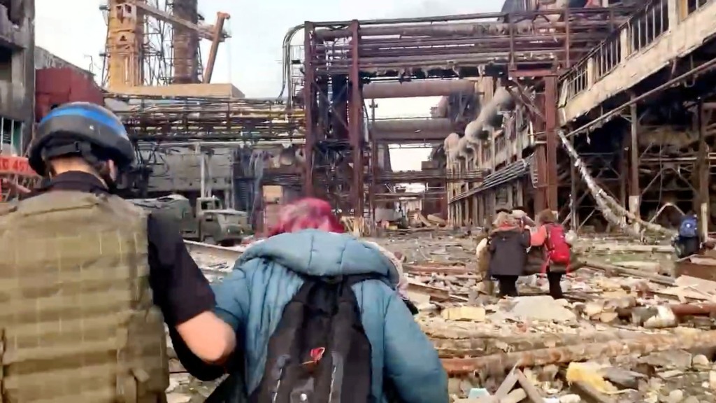 Członkowie Pułku Azowskiego spacerują z cywilami podczas kierowanej przez ONZ ewakuacji z rozległej huty Azovstal, prawie dwa miesiące po wojnie oblężniczej miasta przez Rosję podczas inwazji, w Mariupolu na Ukrainie na tym zdjęciu z postu opublikowanego 1 maja 2022 r. . 