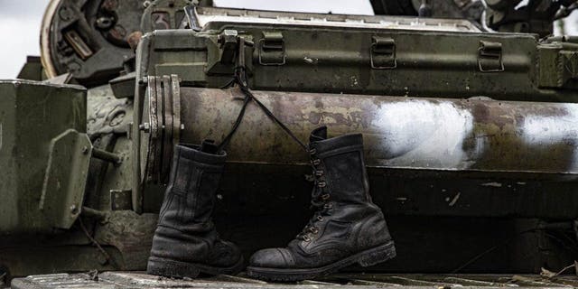 Uszkodzony rosyjski pojazd wojskowy i buty są widoczne po wycofaniu się sił rosyjskich, gdy wojna rosyjsko-ukraińska trwa w Izium w obwodzie charkowskim na Ukrainie 14 września 2022 r.