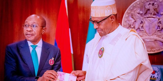 PLIK: Godwin Emefele, po lewej, prezes Banku Centralnego Nigerii (CBN), uczestniczy w prezentacji nowych banknotów po tym, jak prezydent Nigerii Muhammadu Buhari, po prawej, odsłonił nowo zaprojektowane banknoty z powodu fałszowania i narastających problemów z bezpieczeństwem 23 listopada 2022 r., w Abudży w Nigerii.